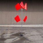 Galvanized steel flag tree stand with T-pin leg release system deployed in a work zone.