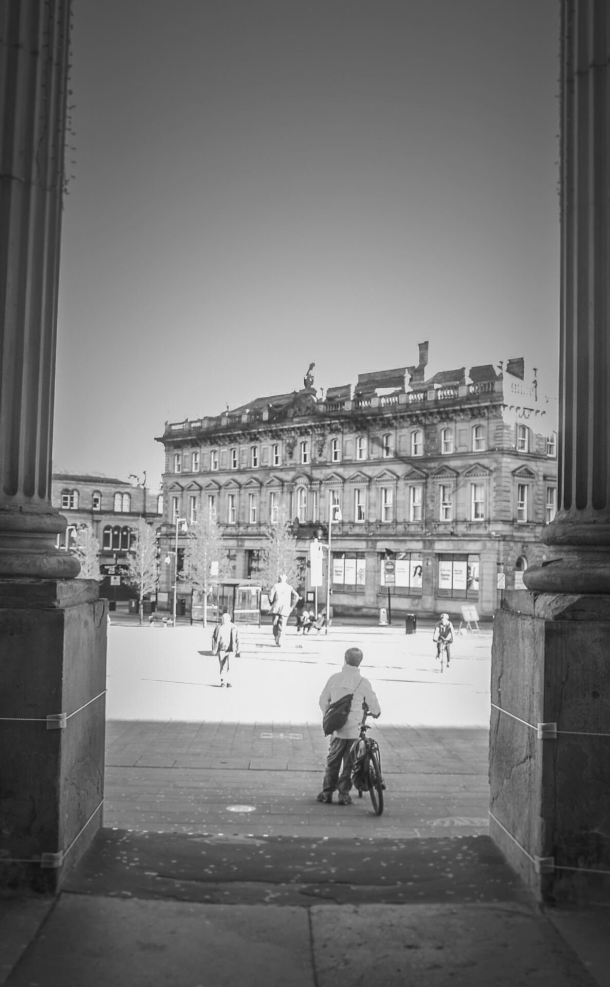 A black and white photo of a person riding a bike