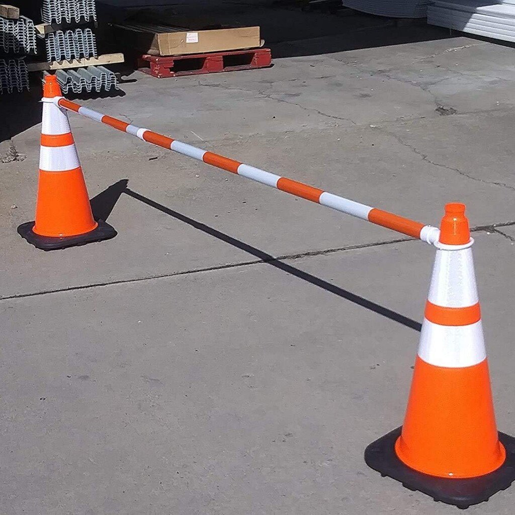 Adjustable reflective cone bar creating a pedestrian barricade between two orange safety cones.