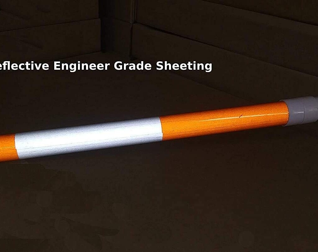 Close up of engineer grade reflective striping on an adjustable cone bar for night time visibility.