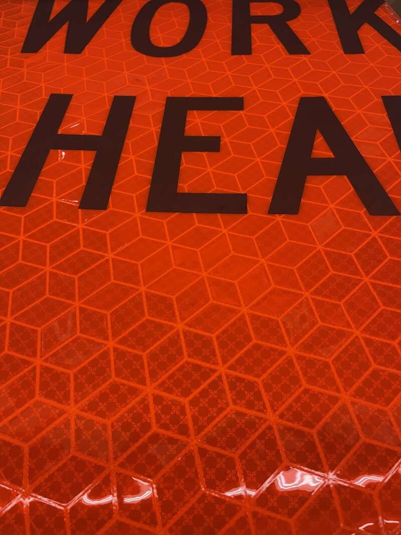 Macro close-up of ORALITE Marathon roll-up sign material showing the heavy-duty reinforced fabric backing